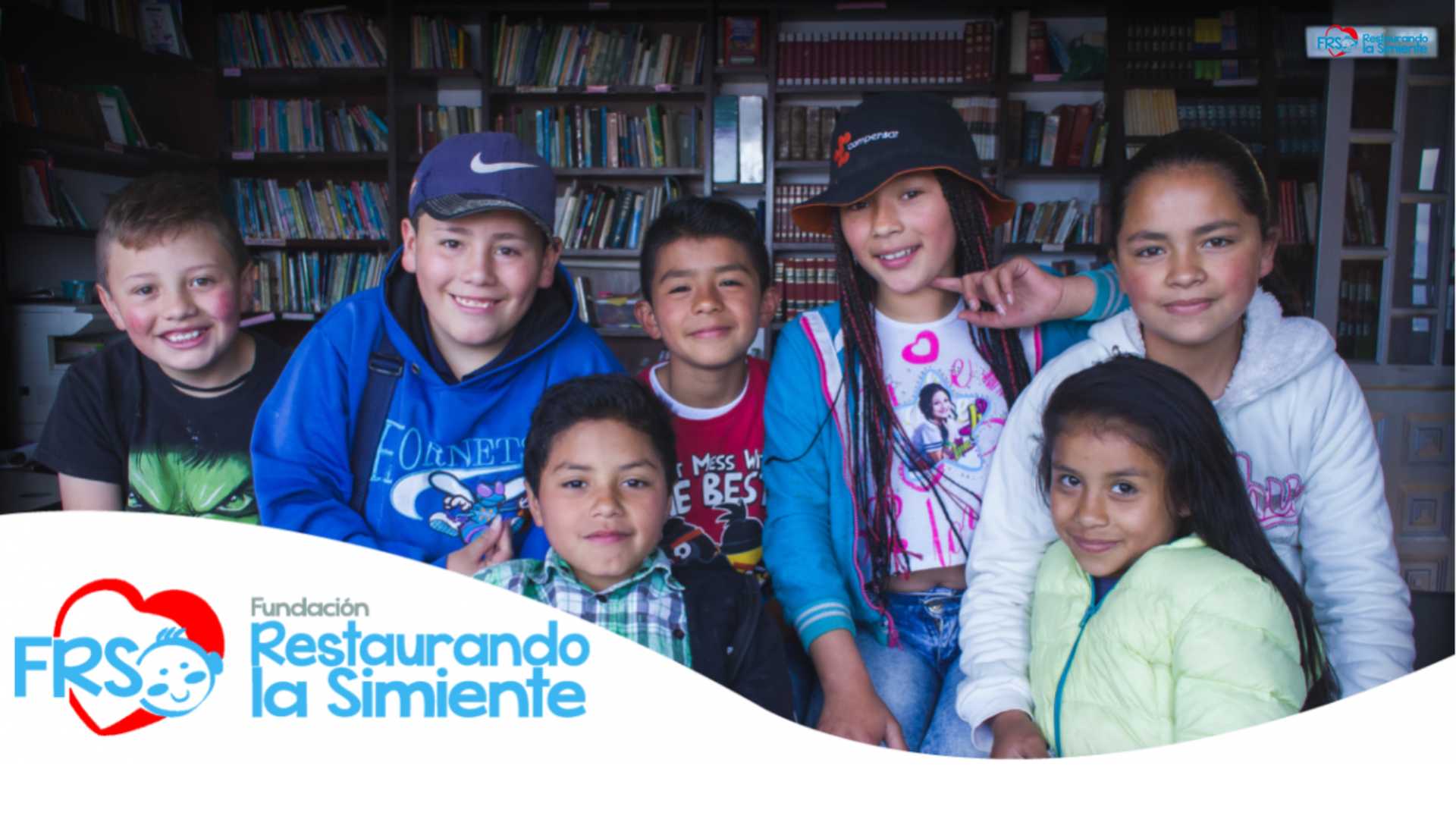 Niños sonriendo en una biblioteca