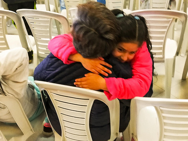 Niña abrazando a una persona en la fundación